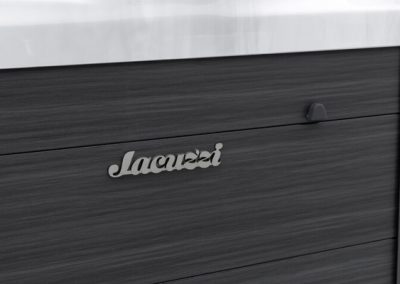 Close-up of a dark wood dresser drawer with a small rounded metal handle under a light countertop edge.