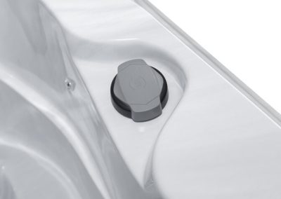 Gray circular cap with a hexagonal top set in a recessed white surface area.