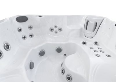 White hot tub interior with multiple massage jets and built-in seating for lounging and sooting water therapy.