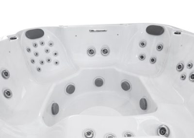 White acrylic hot tub interior with built-in seating and many jet nozzles along each seat corner and wall for hydrotherapy.