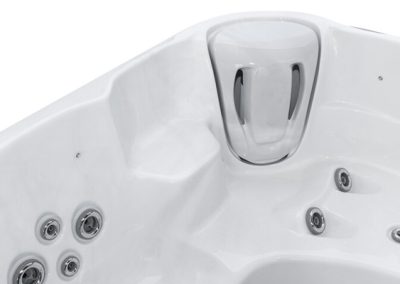 Close-up of a white hot tub seat showing multiple silver jet nozzles and a curved headrest area for relaxing pours of water.