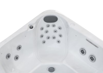 White hot tub interior with multiple silver jets and a curved seating area at the top edge.