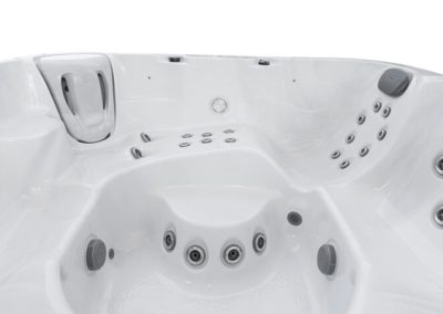 White hot tub interior with multiple water jets and molded seats, including built-in headrests.