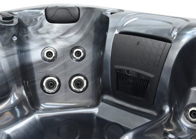 Close view of a metallic hot tub interior showing four jet nozzles and a built-in control panel.