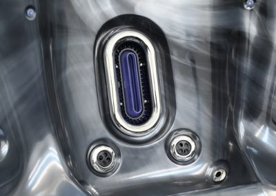 Close-up of a stainless steel machine chamber with an oval purple gasket and surrounding screws