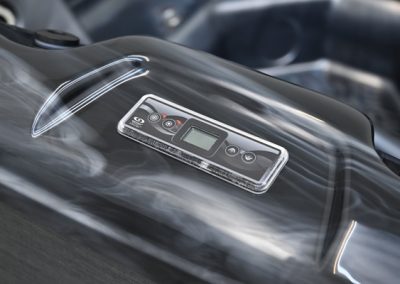 Digital control panel on a glossy black barbecue grill lid, showing temperature display and buttons to adjust settings