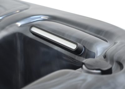 Close-up of a toaster slot with a silver bread guide inside, viewed from above.
